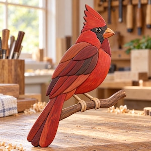 May include: A handcrafted wooden cardinal bird sculpture featuring layered red and dark brown wood segments. The bird has a prominent crest, a black face mask, and a light orange beak, perched on a textured brown wooden branch.
