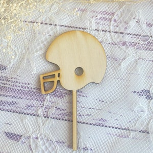 Pu&ograve; includere: Un ritaglio di legno di un casco da football americano, perfetto per decorare torte o progetti di artigianato.