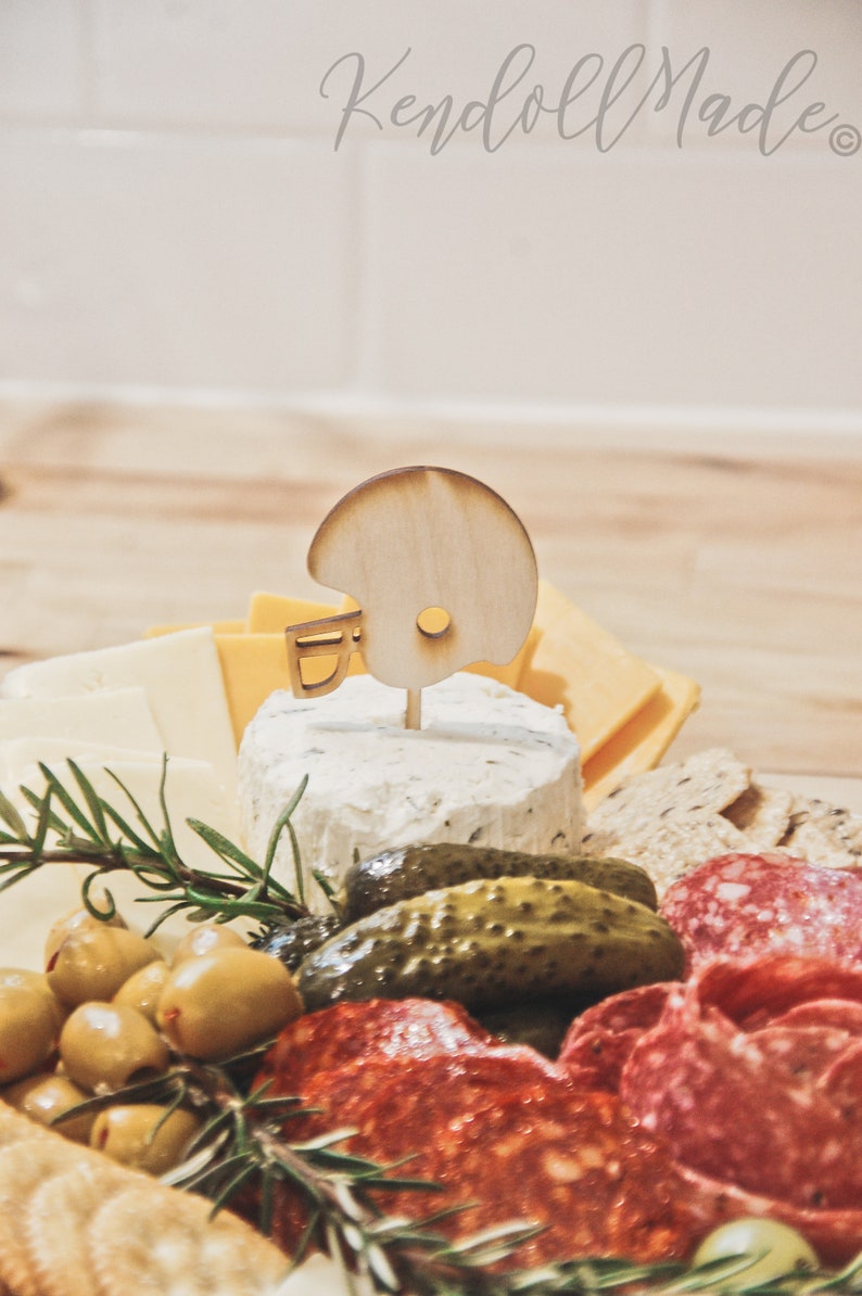 These football helmet party food picks are the perfect Game Day Decoration! Use them in your charcuterie board, as cupcake toppers, or place around! They are the perfect wood label for your Sports Theme Party Decor