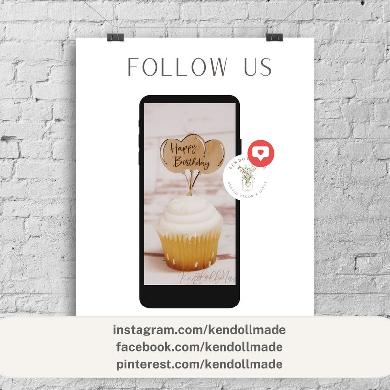 Pu&ograve; includere: Un topper per cupcake in legno con le parole "Happy Birthday" su di esso. Il topper ha la forma di una nuvola con due cuori. Il topper &egrave; in cima a un cupcake con glassa bianca e codette. Il cupcake &egrave; su uno schermo di telefono con le parole "kendolmade" in basso. Lo schermo del telefono &egrave; su uno sfondo bianco con le parole "FOLLOW US" in alto. L'immagine include anche un'icona di social media con un cuore e le parole "kendolmade rustic decor & gifts".