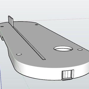 May include: A light gray, elongated, flat mechanical component with rounded ends. It features a central longitudinal slot, a circular opening, several small circular mounting holes, and a small vertical tab protruding from one end.