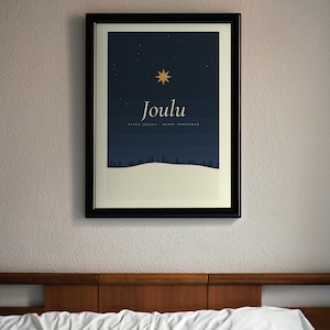Puede incluir: Una lámina artística enmarcada que muestra un cielo nocturno azul oscuro con una estrella dorada, un paisaje nevado con la silueta de un bosque y el texto "Joulu" seguido de "HYVÄÄ JOULUA - MERRY CHRISTMAS" en blanco sobre fondo crema.