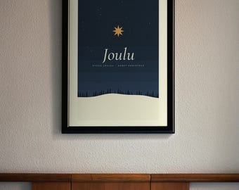 May include: A framed wall art print featuring a dark blue night sky with a gold star, a snowy landscape with a forest silhouette, and the text "Joulu" followed by "HYVÄÄ JOULUA - MERRY CHRISTMAS" in white lettering on a cream background.