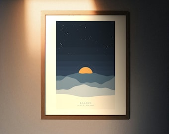 May include: A framed wall art print featuring a stylized landscape with layered blue mountains, a bright orange sun, and a dark starry sky. The bottom section includes the text KAAMOS, coordinates, and the words BLUE HOUR in a clean font.