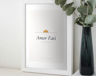May include: A white framed wall art print featuring a light gray background with a small orange semi-circle above a horizontal line. The text reads Amor Fati, Love of Fate, and To want nothing to be different in black serif font.