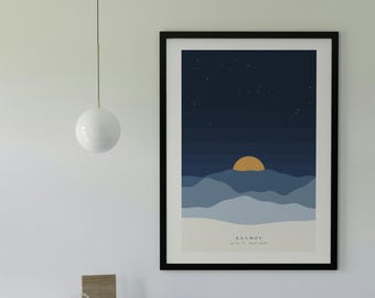 May include: A framed vertical wall art print featuring a stylized landscape with layered blue mountains, a dark starry night sky, and a golden sun. The text KAAMOS is printed at the bottom center of the artwork in a simple black font.