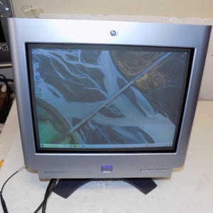 May include: A silver HP Pavilion mx704 CRT computer monitor with a thick bezel, a blue power button, and a screen displaying a high-angle aerial photograph of a bridge over a river. The monitor features the HP logo at the top center.