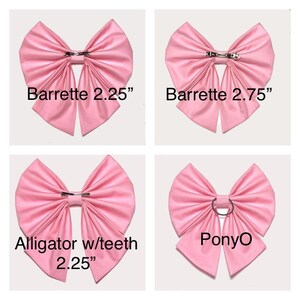 May include: Four pink fabric hair bows with different fasteners. The top left bow is 2.25 inches and has a barrette clip. The top right bow is 2.75 inches and has a barrette clip. The bottom left bow is 2.25 inches and has an alligator clip with teeth. The bottom right bow has a pony O ring.