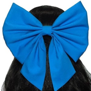 May include: A large, bright blue bow made of fabric. The bow is tied with a long tail and is suitable for use as a hair accessory.