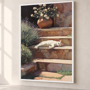 Op de afbeelding: Een ingelijst schilderij met een witte kat die in de zon op stenen treden ligt. Een terracotta pot gevuld met witte rozen staat op de bovenste trede, naast een lavendelstruik. De scène toont warm, natuurlijk licht en steentexturen.