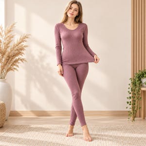 May include: A mauve-coloured long-sleeve top and matching leggings set featuring a ribbed texture. The top has a scoop neckline and long sleeves, while the leggings are fitted and full-length, creating a cohesive two-piece lounge outfit.