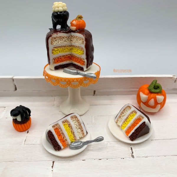 Miniature d’Halloween layer cake présenté sur un stand à gâteaux, petites parts de gâteau et boissons aux couleurs assorties