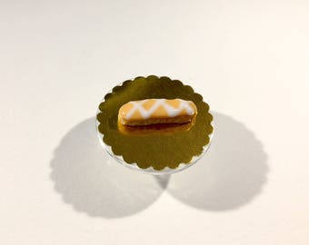 Éclair miniature glaçage orange pâle rayé blanc en pâte polymère