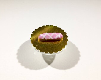 Éclair miniature glaçage rose rayé blanc en pâte polymère
