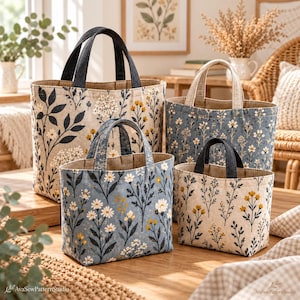May include: A set of four fabric tote bags in varying sizes, featuring floral patterns in shades of blue, cream, and mustard yellow. Each bag has two sturdy handles and a structured, upright design with a visible interior lining.