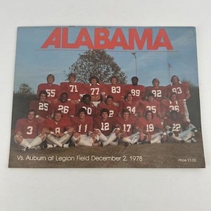 May include: A vintage magazine cover featuring the word "ALABAMA" in red block letters above a team photo. The team is wearing red and white uniforms. The text "Vs. Auburn at Legion Field December 2, 1978" is printed at the bottom.