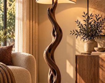 May include: A floor lamp featuring a base made from a twisted, natural brown piece of driftwood. The lamp has a circular dark metal base and a wide, beige fabric lampshade with a curved, overlapping design that emits a soft, warm light.