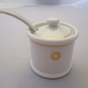 Peut inclure: Sucrier en céramique blanche avec une bordure dorée et une cuillère assortie. Le bol a un motif d'étoile dorée sur le devant.