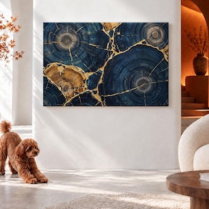 May include: A rectangular wall art piece featuring a cross-section of tree trunks in deep navy blue and natural wood tones, with prominent gold-coloured veins filling the cracks between the circular wood grain patterns.