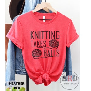 May include: Red t-shirt with the text "Knitting Takes Balls" and a graphic of two balls of yarn.