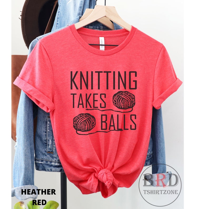 May include: Red t-shirt with the text "Knitting Takes Balls" and a graphic of two balls of yarn.