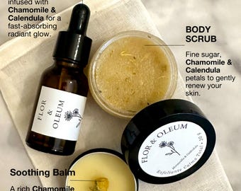 Puede incluir: Un set de cuidado de la piel con un frasco cuentagotas de vidrio marrón etiquetado Flor & Oleum, un tarro de exfoliante corporal granulado y una lata pequeña de bálsamo calmante con una flor seca, sobre una bolsa de tela.
