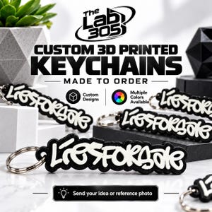 Puede incluir: Varios llaveros impresos en 3D personalizados con el texto L'iesforsale en letras blancas en relieve sobre un fondo negro. Cada llavero incluye una anilla de metal plateado. La imagen contiene el texto: The Lab 305, CUSTOM 3D PRINTED KEYCHAINS, MADE TO ORDER, Custom Designs, Multiple Colors Available, Send your idea or reference photo.