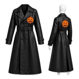 Könnte beinhalten: Ein schwarzer zweireihiger Trenchcoat mit breitem Kragen, Gürtel in der Taille und langen Ärmeln mit Schnallenbündchen. Eine orangefarbene Jack-o'-Lantern-Kürbisgrafik ist auf der linken Brust und auf dem oberen Rücken aufgestickt.