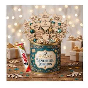 May include: A teal cylindrical tin labeled "DANKE ERZIEHERIN/LEHRERIN" filled with wooden toppers shaped like stars, hearts, and books with German text, plus a Duplo chocolate bar. The tin features gold accents and floral patterns.