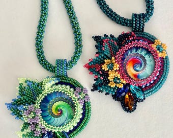 May include: Two beaded necklaces featuring intricate spiral cabochons. The left pendant has green, blue, and lavender beads with a green spiral center. The right pendant has dark blue, pink, and yellow beads with a multi-colored spiral center.