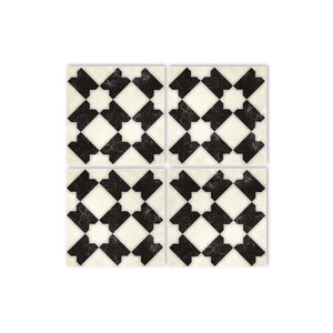 May include: Four black and white square ceramic tiles with a geometric pattern. The tiles have a distressed, vintage look.