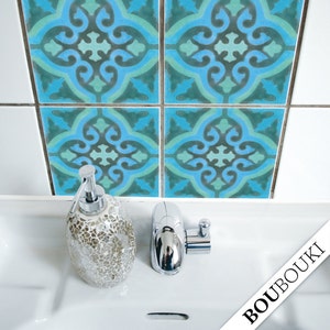 May include: Four blue and green patterned tile stickers with a white grout line. The tiles are on a white bathroom wall above a white porcelain sink with a silver soap dispenser and a silver faucet.