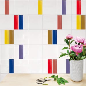 Puede incluir: Azulejos cuadrados blancos con rayas verticales rojas, azules, amarillas, marrones y moradas. Un jarrón blanco con peonías rosas se encuentra sobre una superficie de madera, junto con tijeras y vegetación.