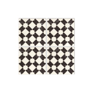 May include: Four black and white patterned square tiles with a geometric design. The tiles have a distressed, vintage look.