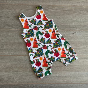 May include: White sleeveless romper with a colorful print of caterpillars, butterflies, watermelons, apples, and suns.