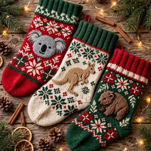 May include: Three knit Christmas stockings featuring festive patterns. The red stocking displays a gray koala face, the cream stocking shows a tan kangaroo, and the green stocking features a brown wombat. Each has a ribbed cuff.
