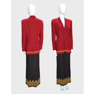 Könnte beinhalten: Ein roter Nadelstreifen-Blazer und ein schwarz-goldener Rock werden auf einer Schaufensterpuppe präsentiert. Der Blazer hat einen goldenen Besatz an der Taille und der Rock ein goldenes Dekor am Saum. Das Outfit ist ein zweiteiliges Set.