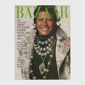 May include: October 1970 Harper's Bazaar magazine cover featuring a smiling woman wearing a green top and a white jacket with floral embroidery. She is adorned with layered necklaces and a pendant. The magazine title is in green.