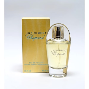 Peut inclure: Un ensemble de parfum avec flacon et boîte. Le flacon transparent contient un liquide de couleur or. La boîte et le flacon portent l'inscription "INFINIMENT Chopard". Le flacon est de 30 ml.