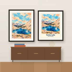 Colorful Guitar Lake artwork and its place-name poster, framed side by side above a wooden sideboard, shown as a room mockup