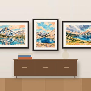 Three colorful Sierra lake prints framed in a row above a wooden sideboard, shown as a room mockup