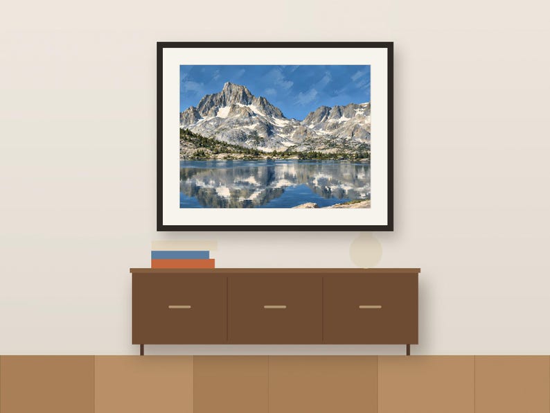 Thousand Island Lake gouache-style print in a dark frame above a wooden sideboard, shown as a room mockup