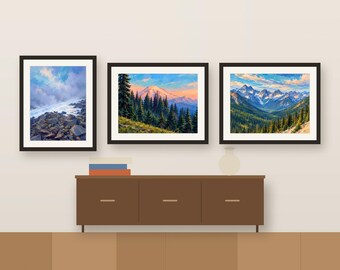 Könnte beinhalten: Drei gerahmte Landschaftskunst-Drucke an einer Wand. Der linke Druck zeigt ein felsiges Ufer unter einem bewölkten Himmel. Der mittlere Druck zeigt einen schneebedeckten Berggipfel hinter Kiefern. Der rechte Druck zeigt ein Bergtal.