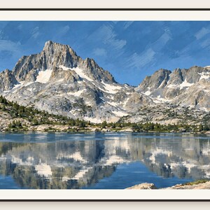 May include: A framed landscape print featuring a jagged, snow-capped mountain peak rising above a calm lake. The mountain is reflected in the water, with patches of green pine trees along the shoreline under a bright blue sky with brushstroke textures.