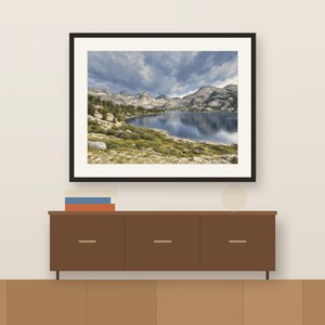 Rae Lakes gouache-style print in a dark frame above a wooden sideboard, shown as a room mockup