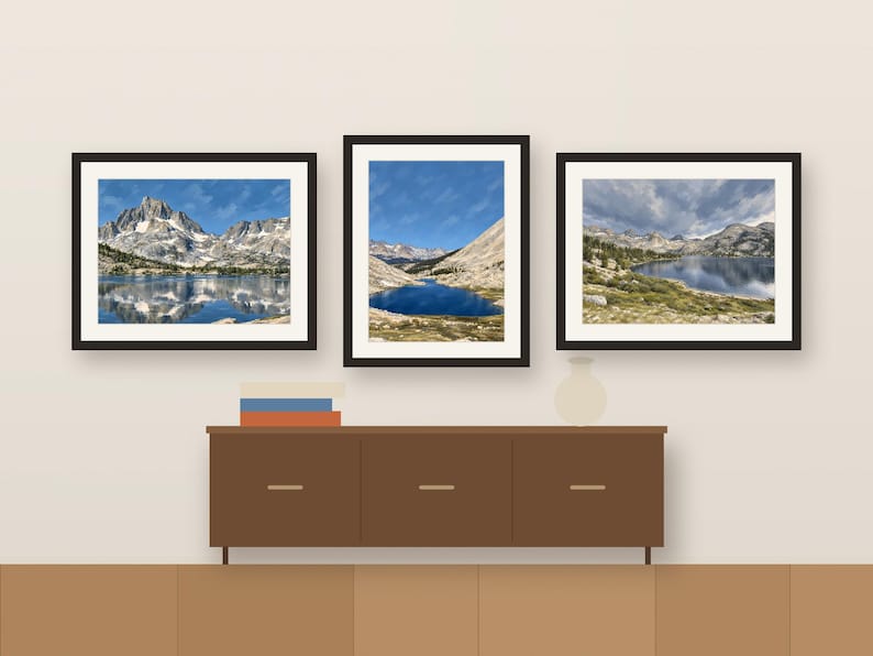 Three framed Sierra lake prints in a row above a wooden sideboard, shown as a room mockup