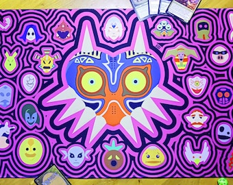 Può includere: Un tappetino da gioco rettangolare con una grande maschera stilizzata centrale dotata di occhi giallo brillante, accenti arancioni e motivi circolari concentrici viola e rosa. Il design include numerose piccole icone colorate dei personaggi.