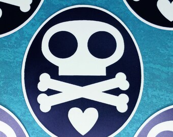 Può includere: Un adesivo circolare con uno sfondo blu scuro e un design grafico bianco. Il disegno è composto da un teschio stilizzato con grandi orbite circolari, un paio di ossa incrociate posizionate sotto il teschio e un cuore nella parte inferiore.