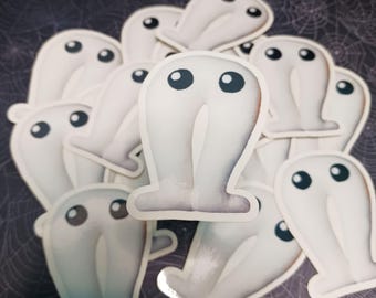 Può includere: Una collezione di adesivi a forma di fantasma bianco. Ogni adesivo presenta un fantasma stilizzato con grandi occhi scuri e un corpo arrotondato. Gli adesivi sono disposti su uno sfondo scuro con un motivo a ragnatela.