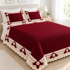 May include: A deep red crochet bedspread and two matching pillow shams featuring a cream-colored border with a grid pattern and decorative three-dimensional floral appliqués in red and cream, finished with a scalloped edge detail.